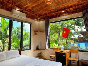 ein Schlafzimmer mit einem Bett und einem Schreibtisch mit einer Flagge in der Unterkunft Ninh Binh Royal Bungalow in Xuân Sơn