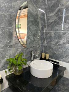 ein Badezimmer mit einem Waschbecken und einem Spiegel auf einer Ablage in der Unterkunft Ninh Binh Royal Bungalow in Xuân Sơn