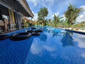 ein Schwimmbecken mit schwarzen Objekten im Wasser in der Unterkunft Ninh Binh Royal Bungalow in Xuân Sơn + 19 Fotos