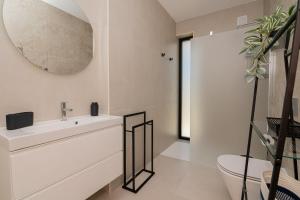 een badkamer met een witte wastafel en een spiegel bij Sirius House in Guia