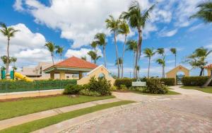 a house with palm trees and a playground at Villa Arrecife Community Pool w Ocean View in Dorado
