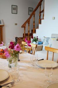 een tafel met glazen en bloemen erop bij Casa Furletti Holiday Home in Tenno