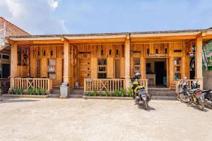 twee motorfietsen geparkeerd voor een houten gebouw bij RedDoorz near Kawah Putih Ciwidey in Bandung +9 foto's