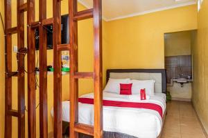 een slaapkamer met een stapelbed met rode kussens erop bij RedDoorz near Kawah Putih Ciwidey in Bandung