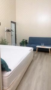 une chambre avec un grand lit et un canapé bleu dans l'établissement Bloom Homestay, à Ninh Binh