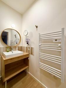 ein Badezimmer mit Waschbecken und Spiegel in der Unterkunft L'Oranger bleu in Royan