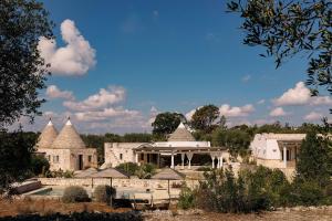 a large building with a pool in front of it at Regina di Ulivi in Ostuni