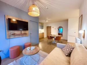 ein Wohnzimmer mit Sofa und Tisch in der Unterkunft L'Oranger bleu in Royan