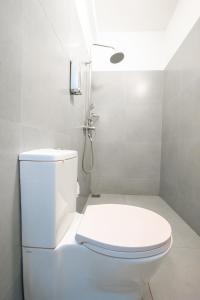 ein weißes Badezimmer mit Toilette und Dusche in der Unterkunft Kozy B&B in Mount Lavinia