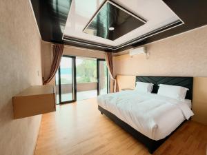 a bedroom with a large bed with a skylight at Rodeo Inn in Ambarita