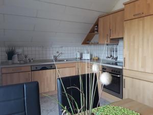 een keuken met houten kasten en een kookplaat met oven bij Ferienwohnung Frischkorn in Steinau an der Straße