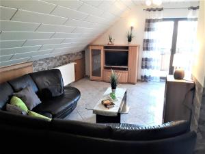 een woonkamer met een bank en een tv bij Ferienwohnung Frischkorn in Steinau an der Straße