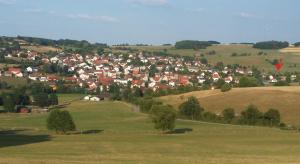 een dorp op een heuvel met een vlieger in de lucht bij Ferienwohnung Frischkorn in Steinau an der Straße