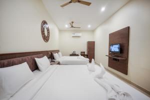 a bedroom with two beds and a flat screen tv at Kayalresidency in Gopichettipālaiyam +29 photos