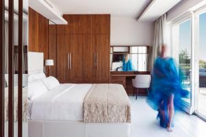 una donna in un vestito blu che cammina in una camera da letto di Lusso Mare Istria Luxury Beach villa a Savudrija Altre 50 foto