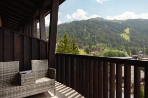 a balcony with two chairs and a view of a mountain at Alpen Hotel Vidi in Madonna di Campiglio