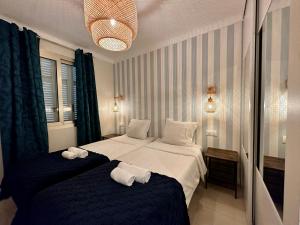 een hotelkamer met twee bedden met handdoeken erop bij Palais du SOLEIL MONACO Terrasse & Parking in Beausoleil