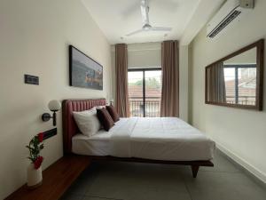 a bedroom with a white bed with a window at Creek Harbour Fort Kochi in Fort Kochi