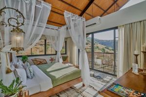 a bedroom with a bed and a large window at SaffronStays Villa Reya in Trimbak +29 photos