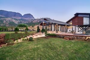 a house with a mountain in the background at SaffronStays Villa Reya in Trimbak