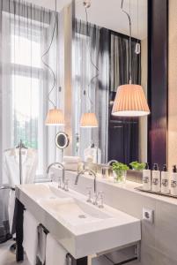 a bathroom with a white sink and two lamps at Hotel Zoo Berlin in Berlin