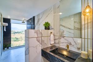 a bathroom with a marble sink and a window at SaffronStays Villa Reya in Trimbak