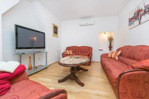 sala de estar con 2 sofás y TV en Haus in Istrien direkt am Meer en Plomin