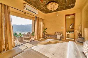 a bedroom with a large bed with a large window at SaffronStays Villa Reya in Trimbak