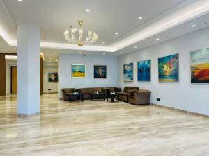 a living room with couches and a chandelier at Vibe By The LaLiT Traveller in Faridabad +35 photos