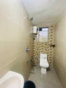 ein kleines Badezimmer mit Toilette und Fenster in der Unterkunft Shubharambha Luxury Resort in Nagaon
