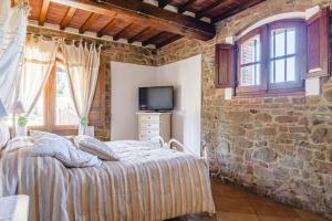 a bedroom with a bed and a stone wall at Il Podere - Rustic Charm in Tuscany in Monte San Savino +37 photos