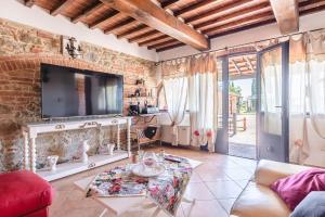 a living room with a tv on a brick wall at Il Podere - Rustic Charm in Tuscany in Monte San Savino
