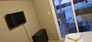 Μια τηλεόραση ή/και κέντρο ψυχαγωγίας στο 2br-7 Guests-Free Parking-Pool-AirCon