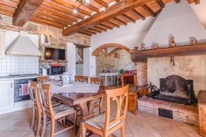 a kitchen with a table and chairs and a fireplace at Il Podere - Rustic Charm in Tuscany in Monte San Savino