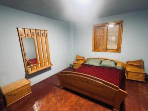 une chambre avec un lit et un miroir au mur dans l'établissement Cabana Valea Lungă, à Telcişor
