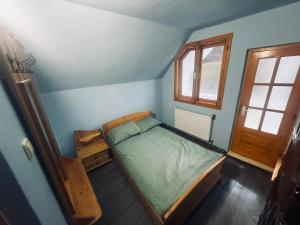 une petite chambre avec un lit et une fenêtre dans l'établissement Cabana Valea Lungă, à Telcişor 1 autre photo