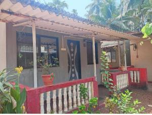 ein Haus mit Zaun und einer Veranda mit Pflanzen in der Unterkunft Om sai villa in Neral