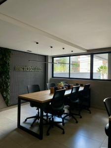 ein Konferenzraum mit einem Holztisch und Stühlen in der Unterkunft Flat aconchegante a 50m do mar do Bessa - até 4 pessoas in João Pessoa + 15 Fotos