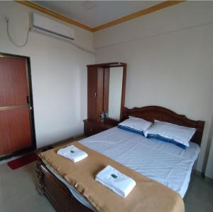 ein Schlafzimmer mit einem Bett, auf dem zwei Handtücher liegen in der Unterkunft Om sai villa in Neral