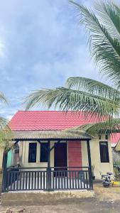 a house with a red roof and a palm tree at sarisare homestay 2BR in Bulakbenda