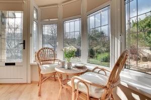 een kamer met een tafel, stoelen en ramen bij 4 Bed in Croyde oc-windy1 in Croyde