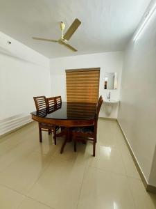 a dining room table with two chairs and a ceiling fan at Zenaura Casa Villa 2 in Cochin