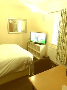 una habitación de hotel con una cama y un televisor en High class accommodations 10, en Little Hulton