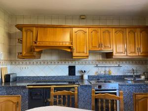 eine Küche mit Holzschränken und einem Herd in der Unterkunft Casa Rosiña in Campo Lameiro