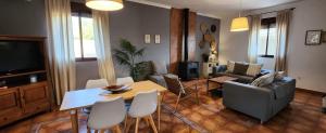 een woonkamer met een bank, een tafel en stoelen bij Villa Boreal in El Gastor