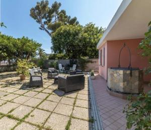 een terras met stoelen en een vuurplaats naast een gebouw bij La casetta rosa in Diano Marina