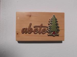 a wooden sign with a tree on a wall at L'Amarena Garden House in Matera +39 photos