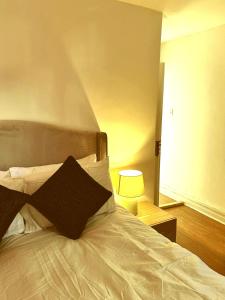 1 dormitorio con cama blanca y almohada negra en High class accommodations 10, en Little Hulton 1 foto más