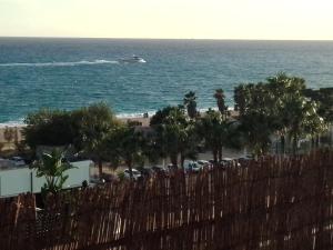 a boat in the ocean with palm trees and a beach at terraza al mar in Pineda de Mar