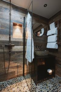 uma casa de banho com um chuveiro e um lavatório com toalhas em Fermain Valley Hotel em St Peter Port